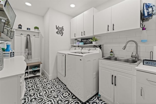 laundry room featuring recessed lighting, cabinet space, a sink, and separate washer and dryer