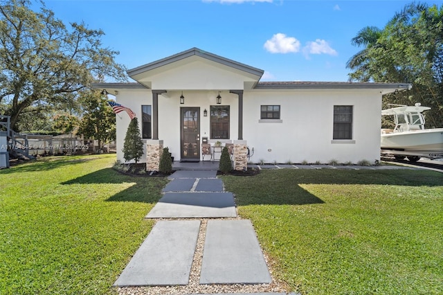 view of front of property featuring a front lawn and stucco siding