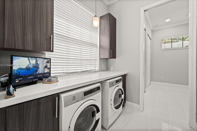 laundry room featuring crown molding, cabinet space, independent washer and dryer, and baseboards