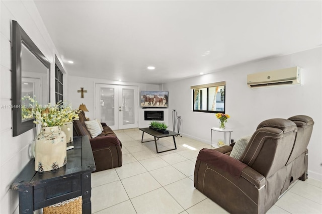 living room featuring an AC wall unit, baseboards, french doors, and light tile patterned floors