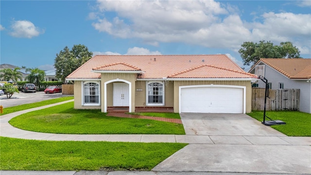 mediterranean / spanish home featuring a garage, driveway, a front yard, and a tile roof