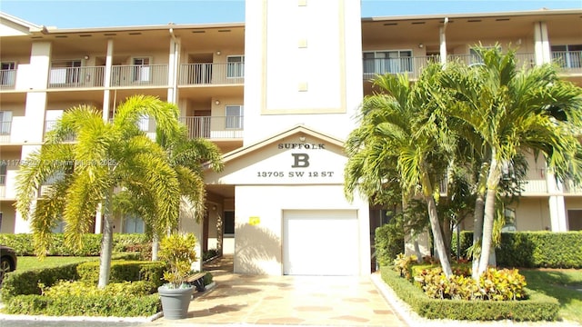 view of property featuring a garage and concrete driveway