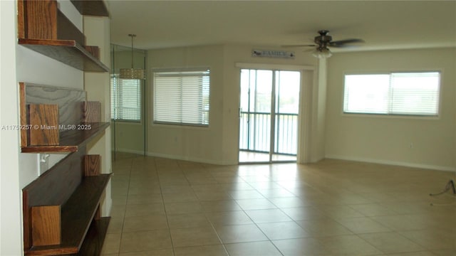 unfurnished room featuring light tile patterned floors, baseboards, and a ceiling fan