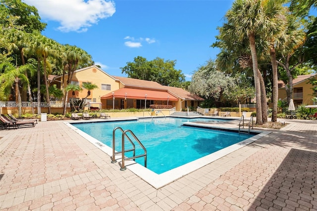 community pool featuring a patio area and fence