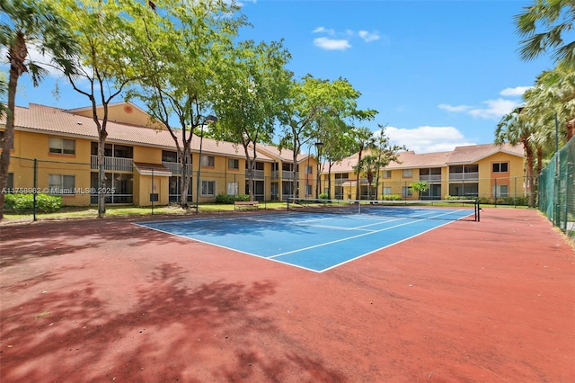 view of sport court featuring fence and a residential view