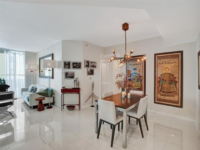 dining space featuring light tile patterned floors, baseboards, and an inviting chandelier