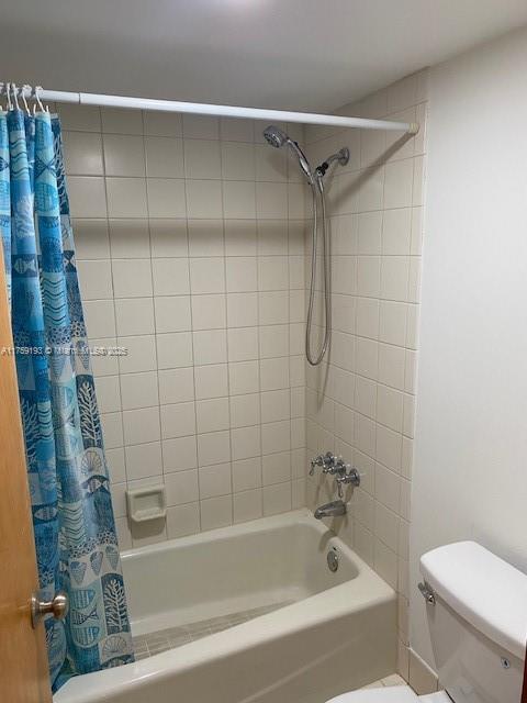 full bathroom with toilet and shower / tub combo with curtain