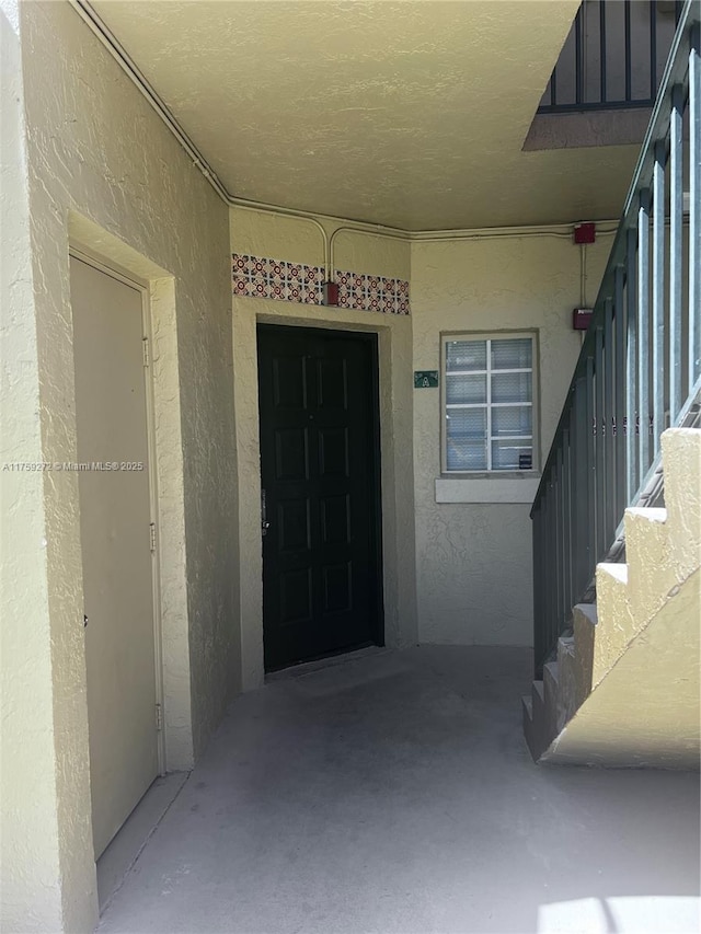 property entrance with stucco siding