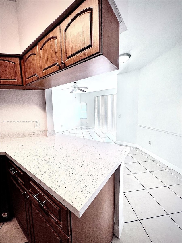 kitchen with light tile patterned floors, ceiling fan, and baseboards