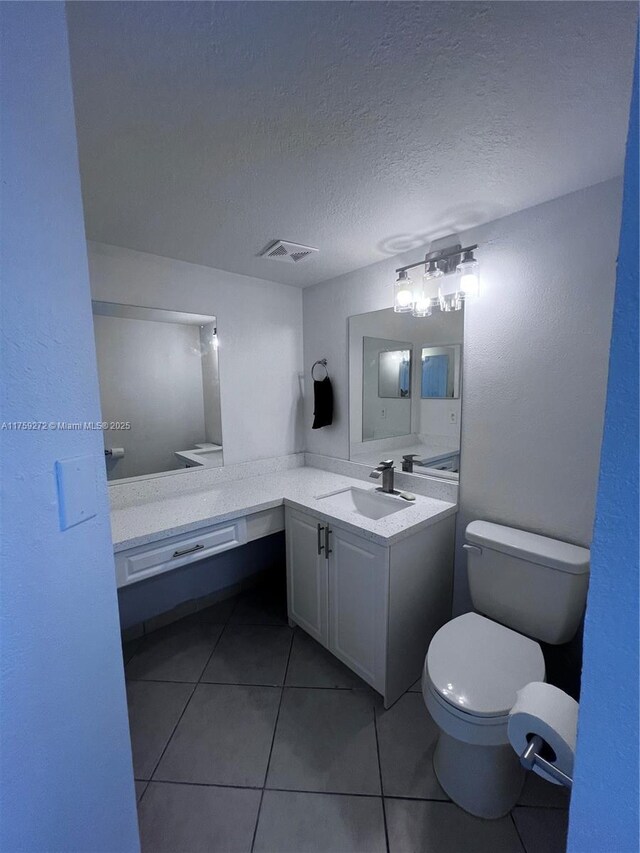 bathroom with a textured ceiling, toilet, vanity, shower / bathing tub combination, and tile patterned floors