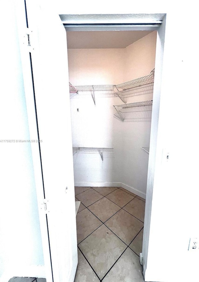 spacious closet with tile patterned floors