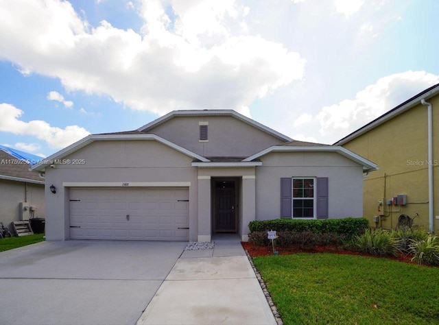 single story home featuring an attached garage, a front lawn, concrete driveway, and stucco siding