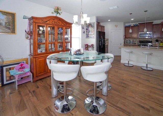 dining space featuring dark wood-style floors, recessed lighting, visible vents, and an inviting chandelier