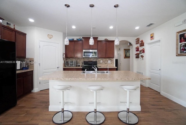 kitchen featuring arched walkways, visible vents, decorative backsplash, a sink, and black appliances