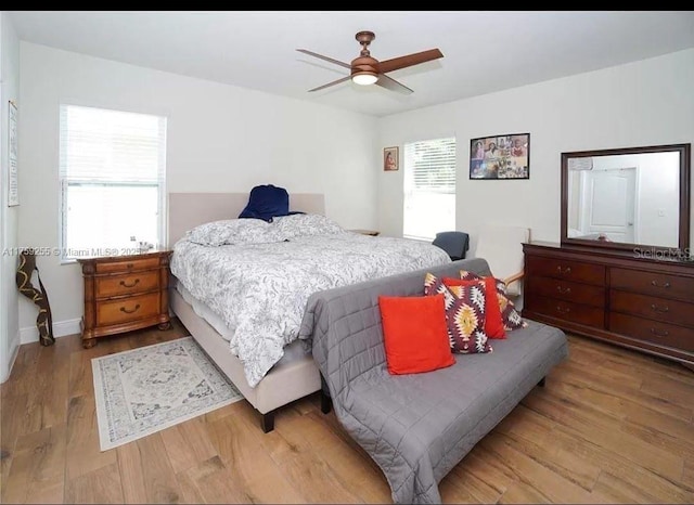 bedroom with light wood-style floors, baseboards, and a ceiling fan