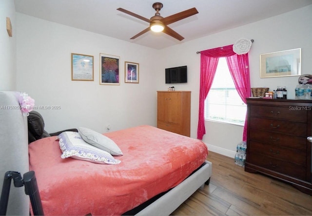 bedroom featuring wood finished floors and baseboards