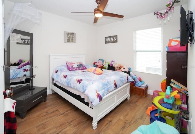 bedroom with ceiling fan, baseboards, and wood finished floors