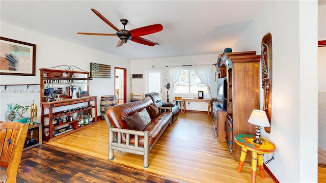 living room featuring wood finished floors and a ceiling fan