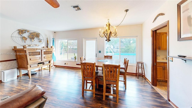 dining area featuring plenty of natural light, visible vents, a chandelier, and dark wood-type flooring