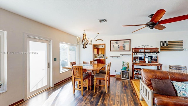 dining room featuring baseboards, visible vents, wood finished floors, and ceiling fan with notable chandelier