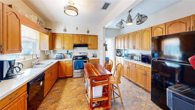 kitchen featuring visible vents, under cabinet range hood, light countertops, black appliances, and a sink