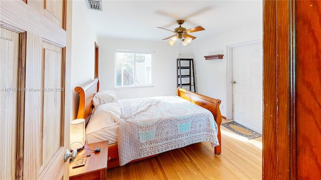 bedroom with visible vents, ceiling fan, and wood finished floors