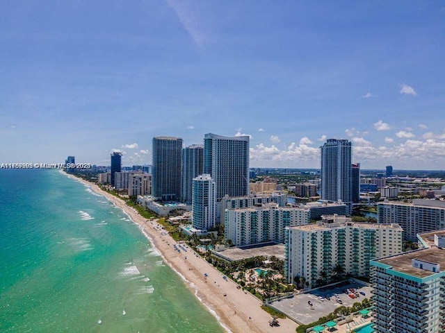 aerial view featuring a city view, a view of the beach, and a water view