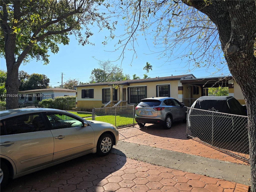 1680 NE 159th St, North Miami Beach, FL 33162 - view of front facade with a fenced front yard and stucco siding