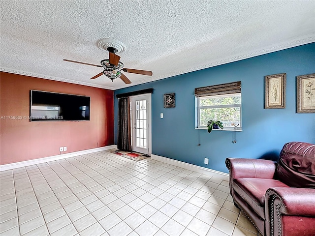 unfurnished room featuring crown molding, light tile patterned floors, a ceiling fan, a textured ceiling, and baseboards