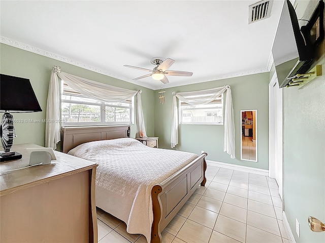 bedroom with light tile patterned floors, ceiling fan, visible vents, baseboards, and ornamental molding