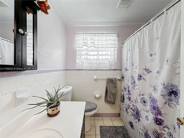 bathroom featuring a textured ceiling, tile patterned flooring, toilet, vanity, and visible vents