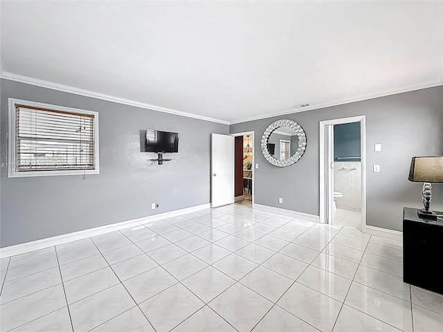 empty room featuring light tile patterned floors, baseboards, and crown molding