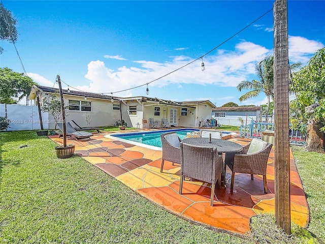 view of pool featuring a fenced in pool, a patio, a lawn, and fence