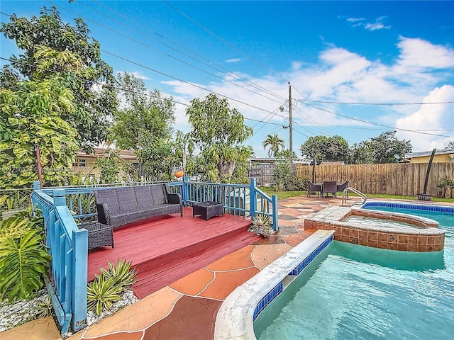 view of swimming pool with a wooden deck, an in ground hot tub, a fenced backyard, and a fenced in pool