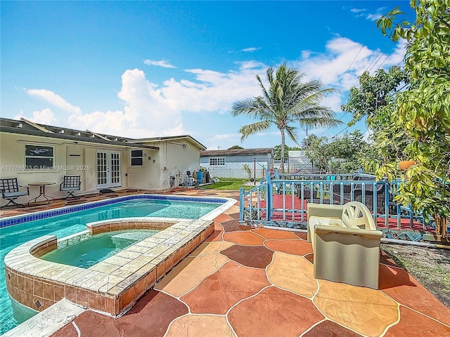 outdoor pool featuring an in ground hot tub, fence, a patio, and french doors