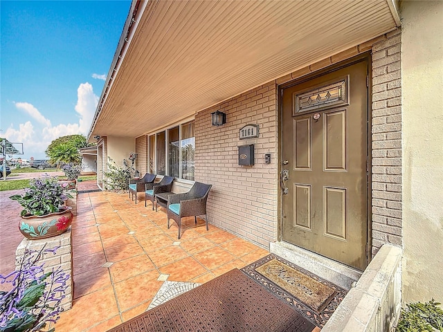 view of exterior entry featuring brick siding and stucco siding