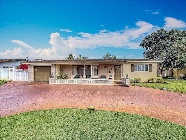 ranch-style house featuring an attached garage, covered porch, fence, and brick siding