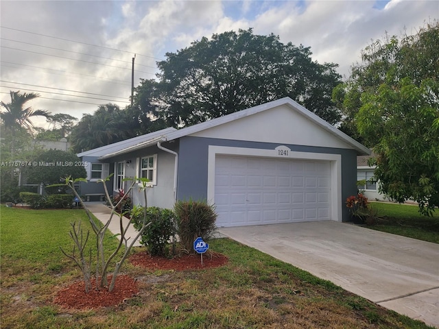 view of front of house with a garage, driveway, a front yard, and stucco siding