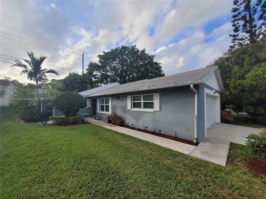 ranch-style house with a garage, a front yard, and stucco siding