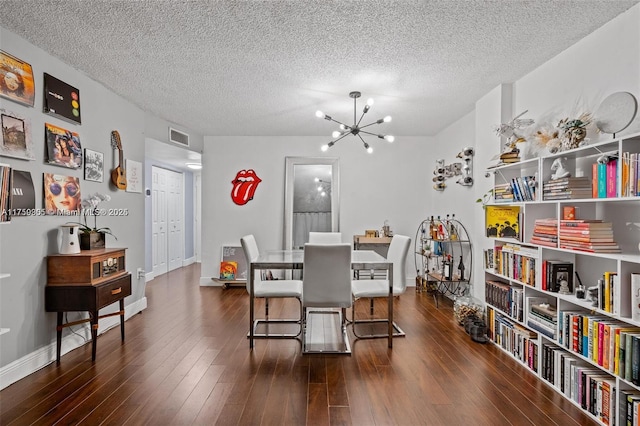 dining space with visible vents, a textured ceiling, a chandelier, baseboards, and hardwood / wood-style flooring