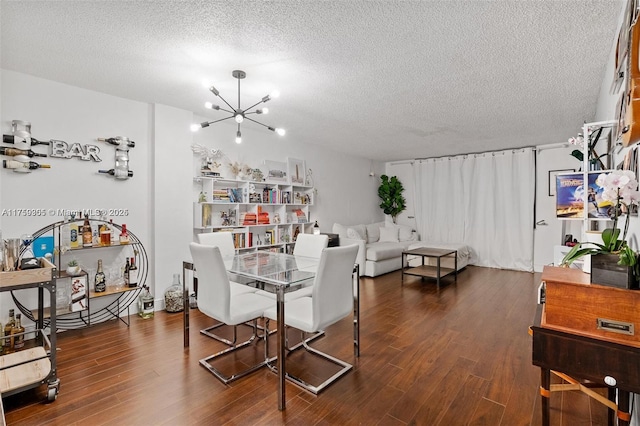 dining space featuring a textured ceiling, a chandelier, and wood finished floors