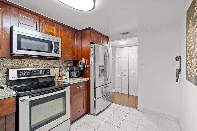 kitchen with light tile patterned floors, appliances with stainless steel finishes, visible vents, and tasteful backsplash