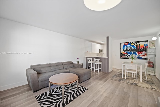 living area featuring light wood-type flooring and baseboards