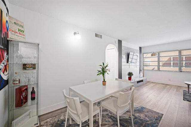 dining space featuring hardwood / wood-style flooring, baseboards, and visible vents