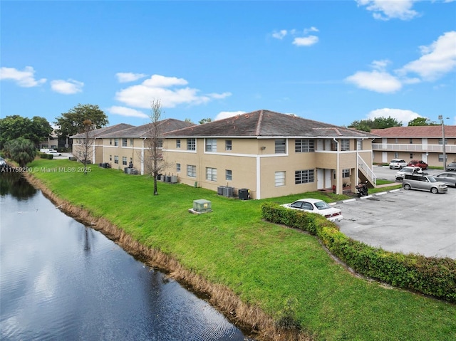 view of property featuring cooling unit, uncovered parking, a residential view, and stairs