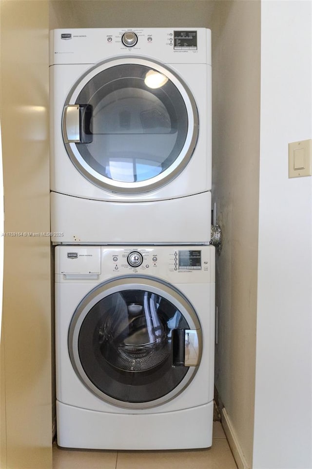 2889 Mcfarlane Rd Unit 1511, Miami, FL 33133 - washroom with baseboards, laundry area, light tile patterned flooring, and stacked washer / drying machine