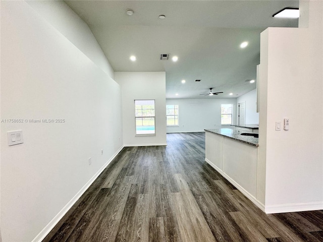 unfurnished living room with dark wood finished floors, visible vents, and baseboards