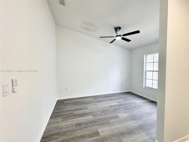 empty room featuring a ceiling fan, visible vents, baseboards, and wood finished floors