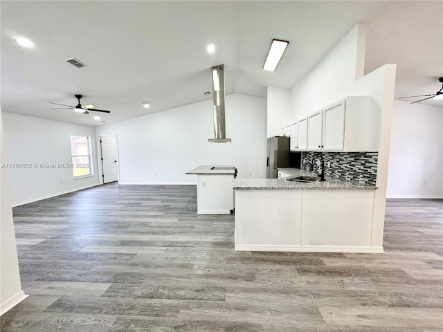 kitchen with visible vents, a ceiling fan, open floor plan, a peninsula, and a sink