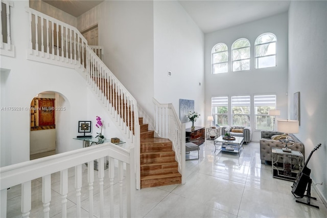 stairs with arched walkways, visible vents, and a high ceiling